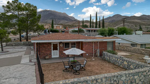a view of a patio with table and chairs under an umbrella