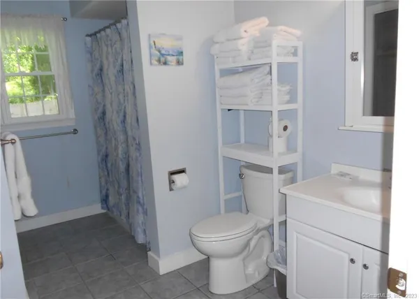 a bathroom with a sink toilet vanity and window