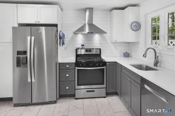 a kitchen with stainless steel appliances granite countertop a refrigerator and a stove