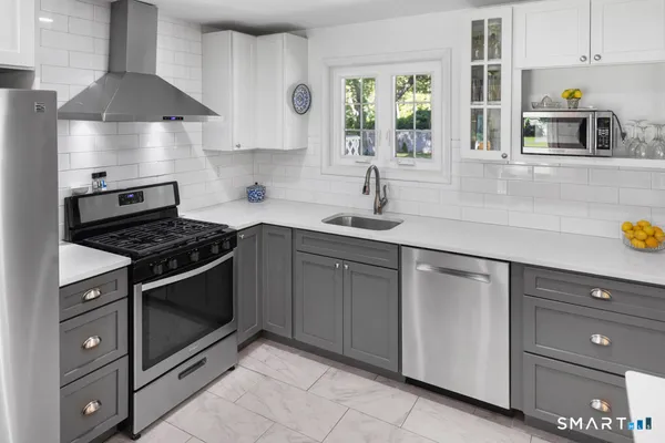 a kitchen with stainless steel appliances granite countertop a sink stove and cabinets