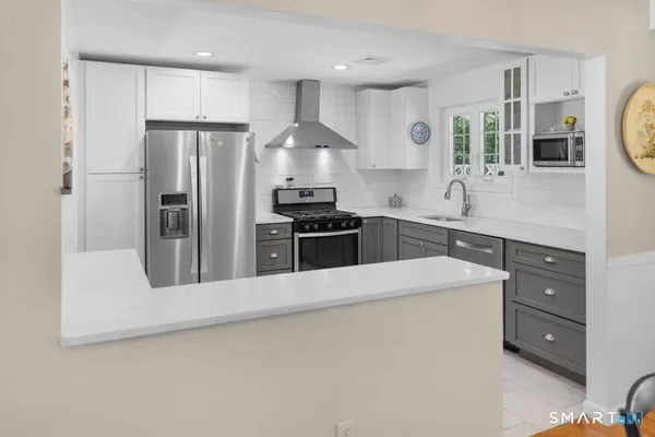 a kitchen with stainless steel appliances a refrigerator sink and stove