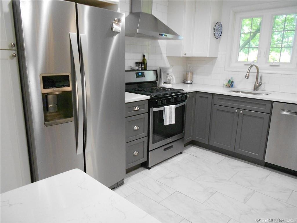 12 Allendale Road Old Saybrook, CT 06475 - Photo 5 of 36 a kitchen with stainless steel appliances granite countertop a refrigerator a sink a stove and white cabinets