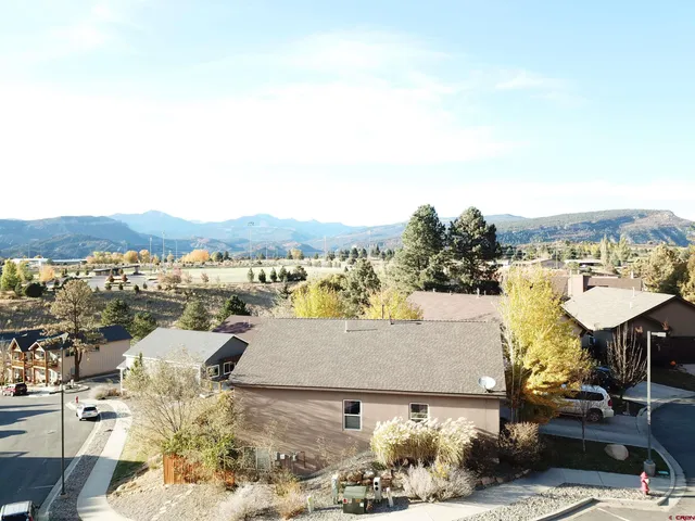 an aerial view of a house with yard and mountain view in back