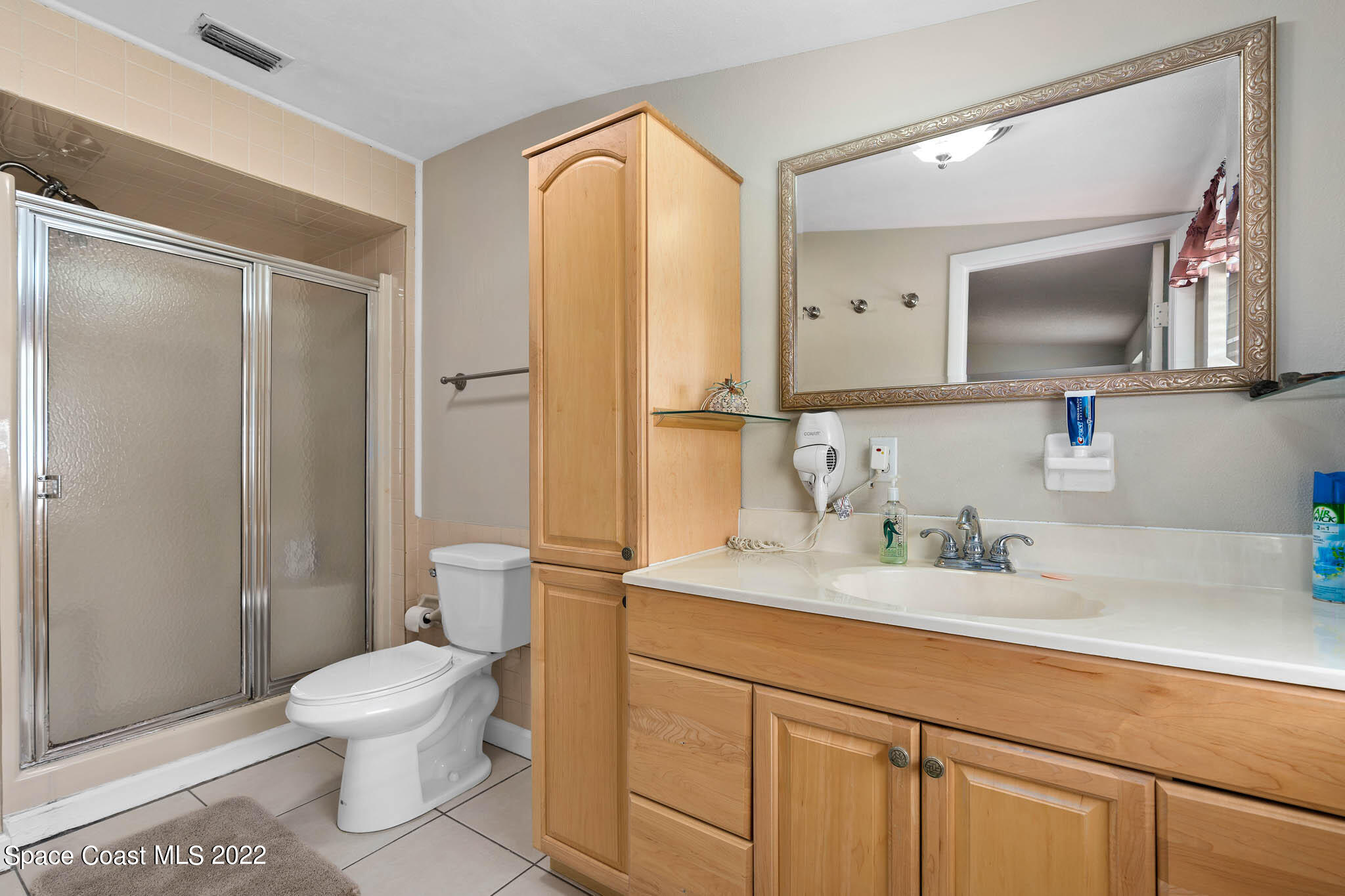 911 Bear Lake Road Apopka, FL 32703 - Photo 23 of 33 a bathroom with a toilet a sink a mirror and a shower