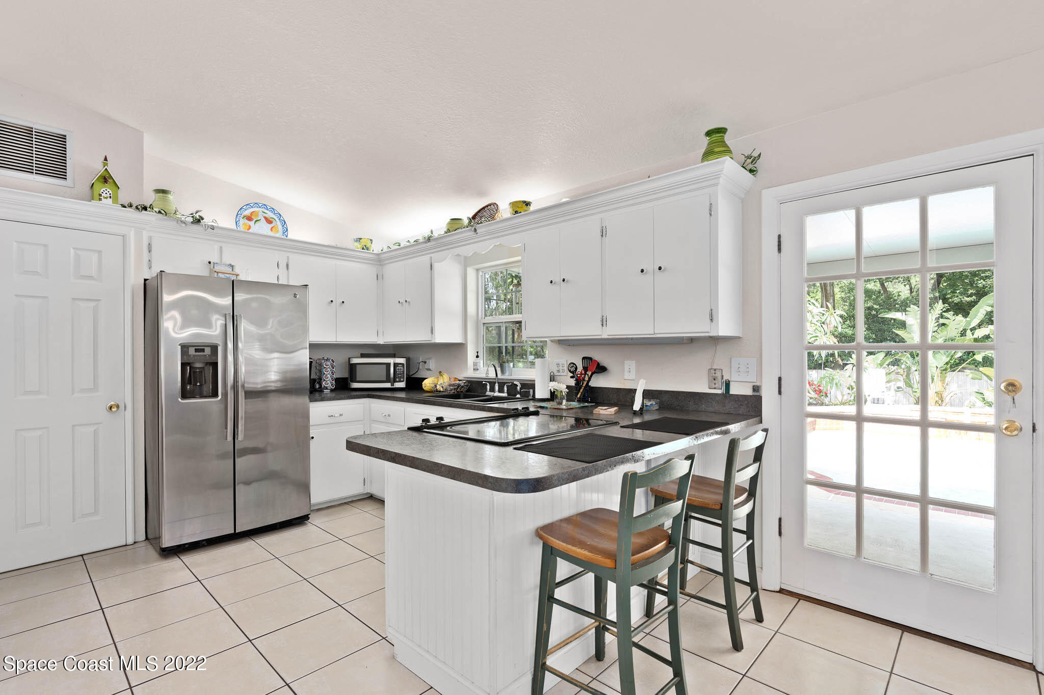 911 Bear Lake Road Apopka, FL 32703 - Photo 7 of 33 a kitchen with stainless steel appliances granite countertop a stove a refrigerator a white table and chairs