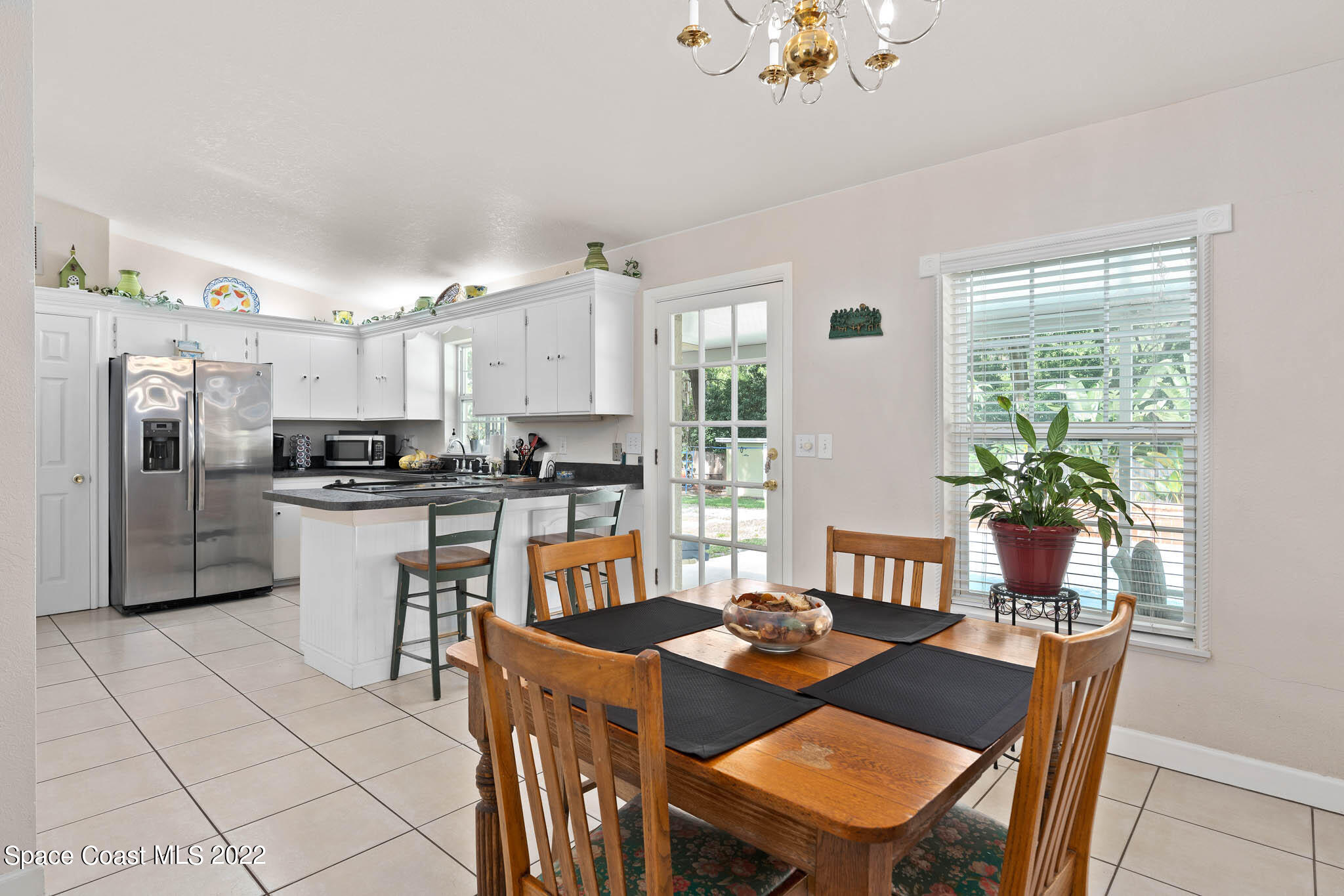 911 Bear Lake Road Apopka, FL 32703 - Photo 9 of 33 a kitchen with a refrigerator a stove a sink dishwasher with a dining table and chairs
