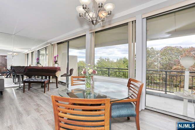 2 Horizon Road, Unit 404 Fort Lee, NJ 07024 - Photo 11 of 30 a dining room with furniture a large window and wooden floor