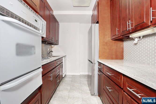 2 Horizon Road, Unit 404 Fort Lee, NJ 07024 - Photo 13 of 30 a kitchen with stainless steel appliances granite countertop a refrigerator and a sink