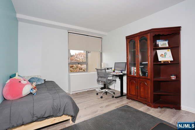 2 Horizon Road, Unit 404 Fort Lee, NJ 07024 - Photo 18 of 30 a bedroom with a bed and a chandelier