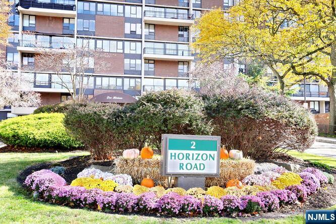 2 Horizon Road, Unit 404 Fort Lee, NJ 07024 - Photo 20 of 30 a street sign that is sitting in front of flowers