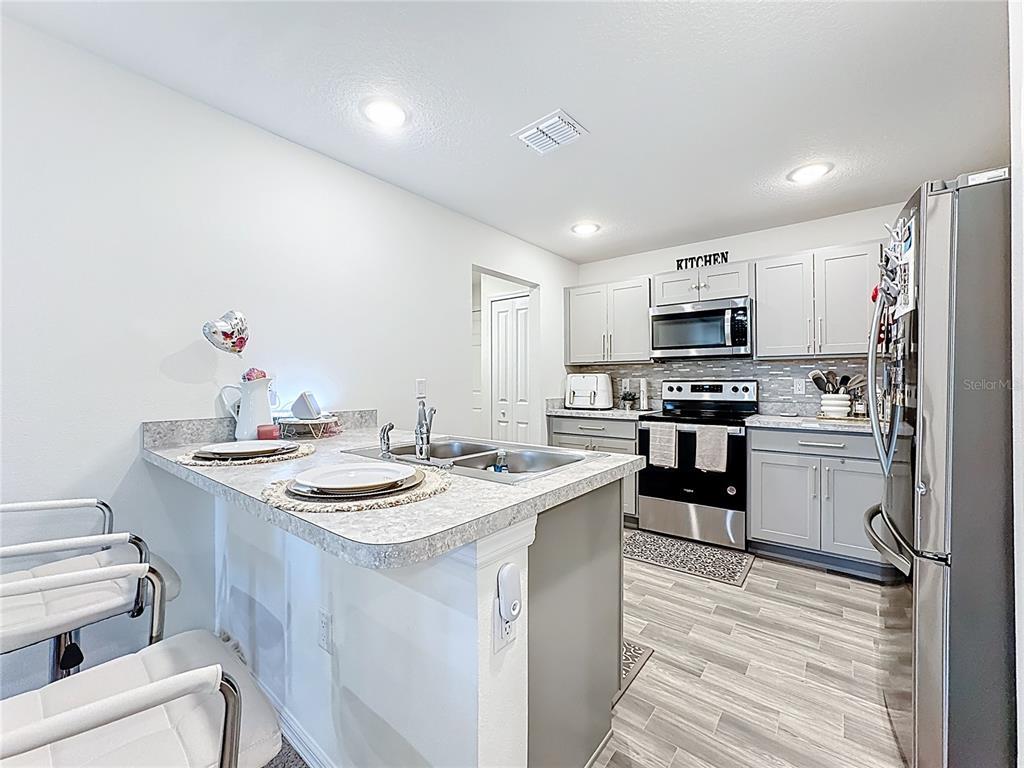 120 Bonito Way Kissimmee, FL 34759 - Photo 14 of 53 a kitchen with a sink stove and refrigerator