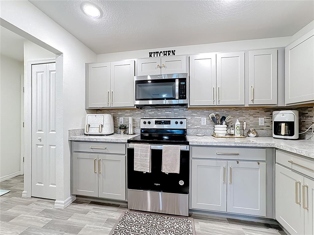 120 Bonito Way Kissimmee, FL 34759 - Photo 15 of 53 a kitchen with stainless steel appliances granite countertop a stove sink and cabinets