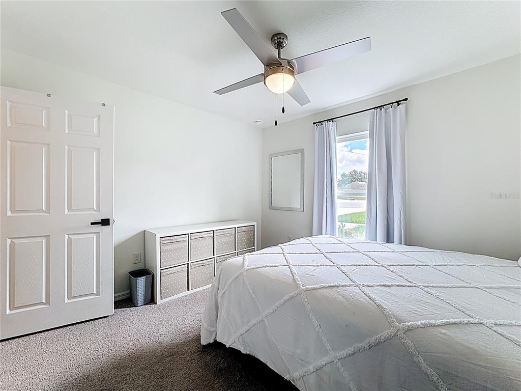 120 Bonito Way Kissimmee, FL 34759 - Photo 20 of 53 a bedroom with a large bed and a chandelier fan