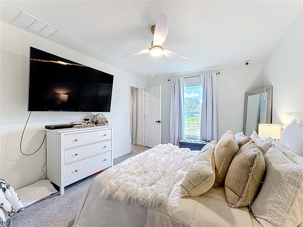 120 Bonito Way Kissimmee, FL 34759 - Photo 27 of 53 a bedroom with a large bed and a flat screen tv