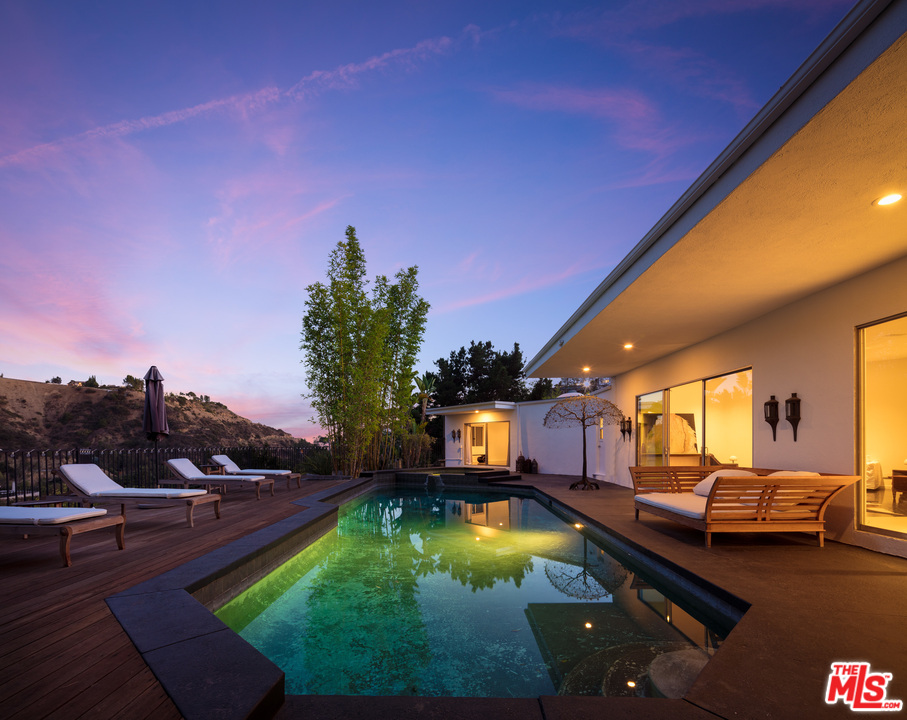 a swimming pool view with a seating space