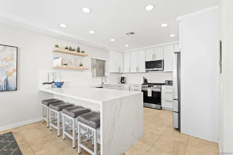 a kitchen with stainless steel appliances a refrigerator sink and white cabinets