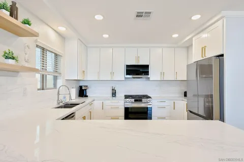 a kitchen with white cabinets stainless steel appliances and sink