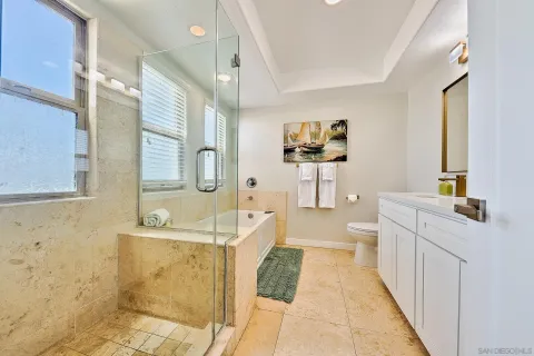 a en suite bathroom with a granite countertop sink and mirror