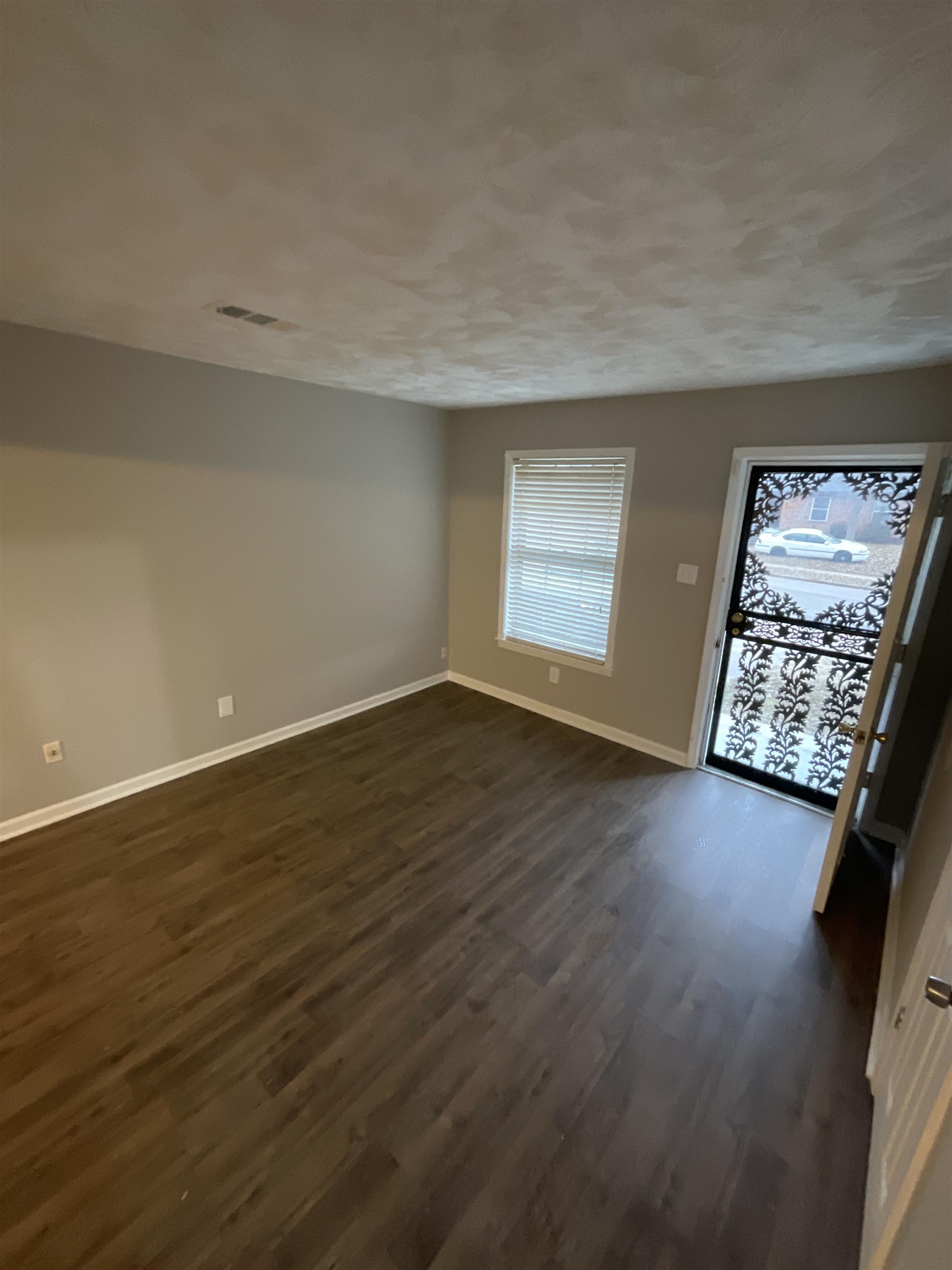 1175 Fiber Road Memphis, TN 38109 - Photo 4 of 9 an empty room with wooden floor and windows