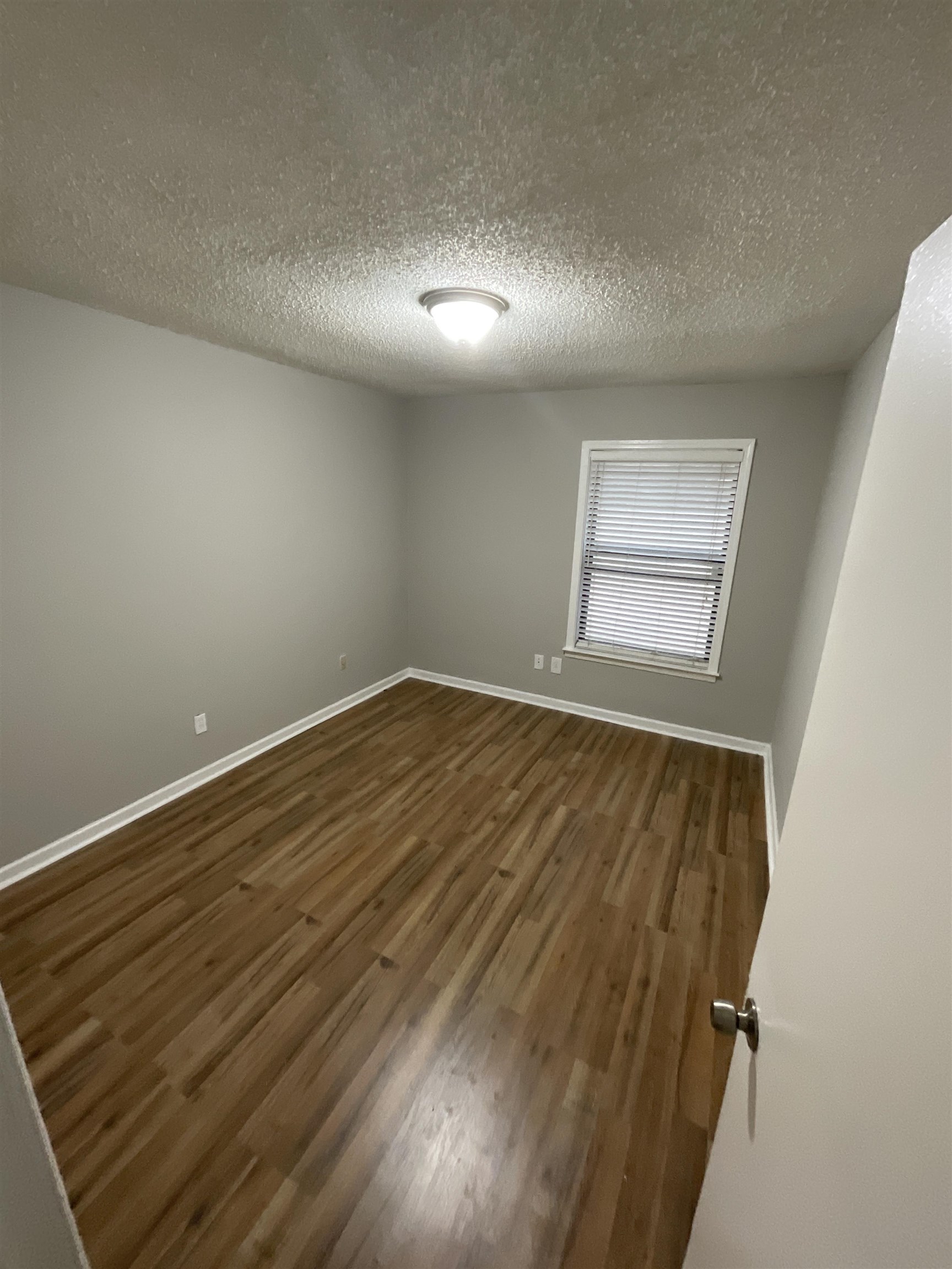 1175 Fiber Road Memphis, TN 38109 - Photo 8 of 9 an empty room with wooden floor and windows