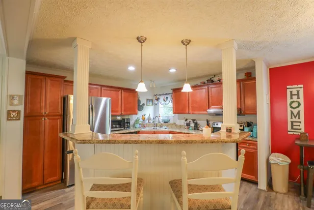 a kitchen with stainless steel appliances granite countertop a refrigerator a sink dishwasher a stove top oven a sink and dishwasher