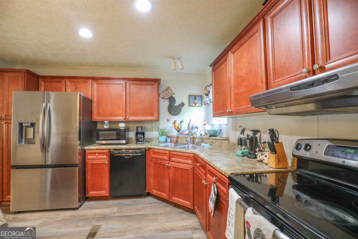 118 Napier Mill Road Southwest Eatonton, GA 31024 - Photo 13 of 33 a kitchen with stainless steel appliances granite countertop a refrigerator a sink dishwasher a stove top oven a sink and dishwasher