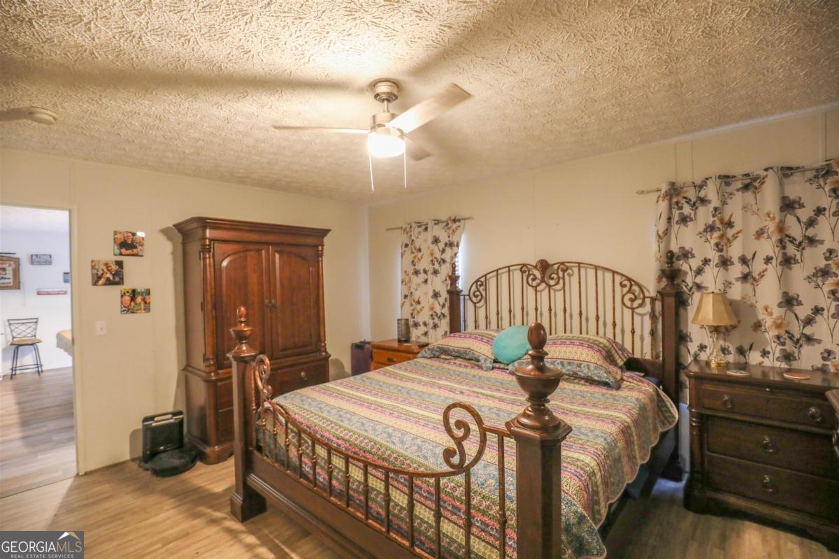 118 Napier Mill Road Southwest Eatonton, GA 31024 - Photo 16 of 33 a bedroom with a bed and a chandelier