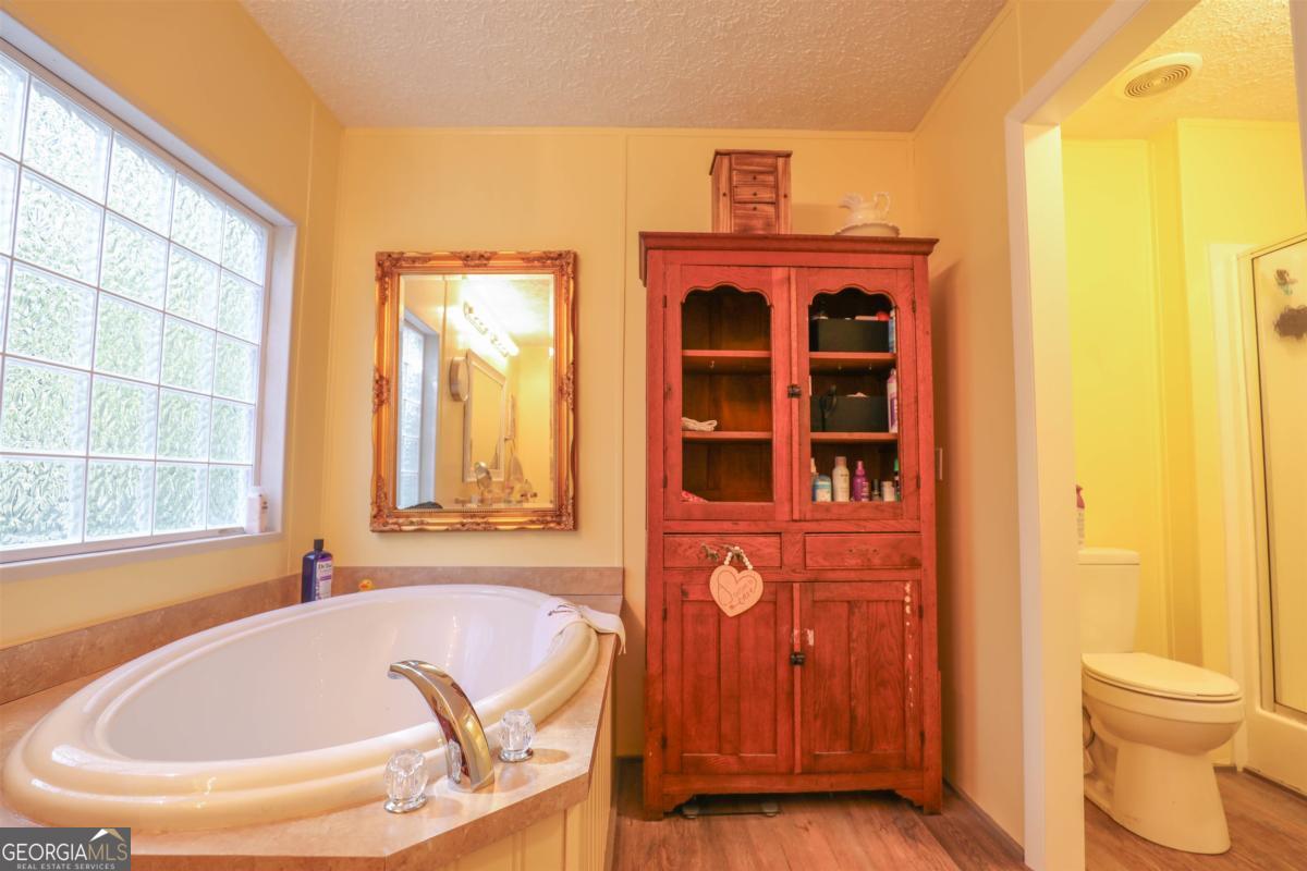 118 Napier Mill Road Southwest Eatonton, GA 31024 - Photo 18 of 33 a bathroom with a tub and shower