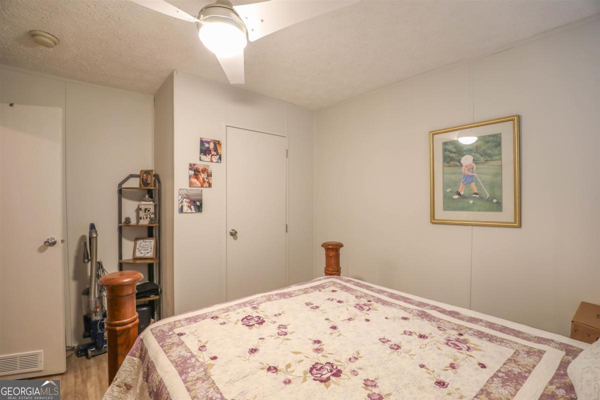 118 Napier Mill Road Southwest Eatonton, GA 31024 - Photo 20 of 33 a bedroom with a bed and a dresser in it