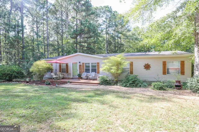 a front view of a house with a yard and trees