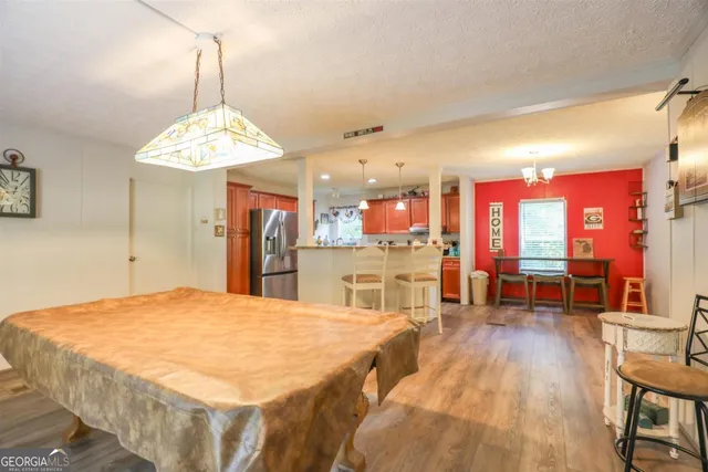 a living room with stainless steel appliances kitchen island granite countertop furniture and a dining table
