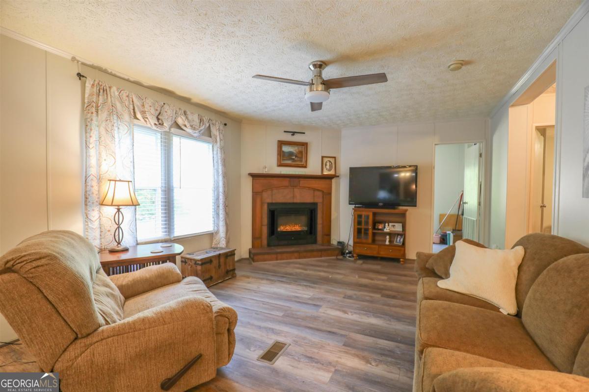 118 Napier Mill Road Southwest Eatonton, GA 31024 - Photo 9 of 33 a living room with furniture large window and a fireplace