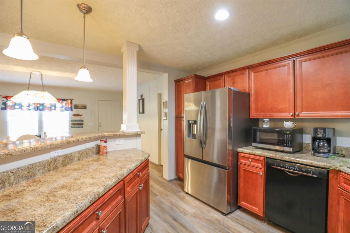 118 Napier Mill Road Southwest Eatonton, GA 31024 - Photo 10 of 33 a kitchen with stainless steel appliances granite countertop a sink refrigerator and cabinets