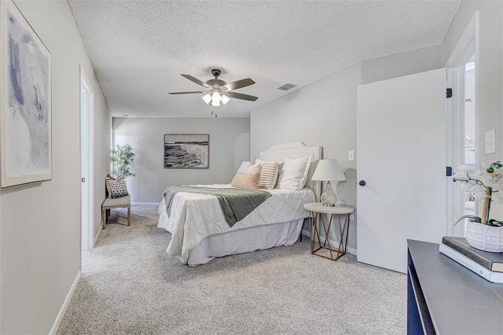 900 Highway 630 East Frostproof, FL 33843 - Photo 17 of 56 a spacious bedroom with a bed and a chandelier