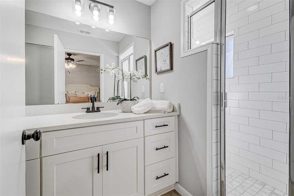 900 Highway 630 East Frostproof, FL 33843 - Photo 21 of 56 a bathroom with a double vanity sink a mirror and shower