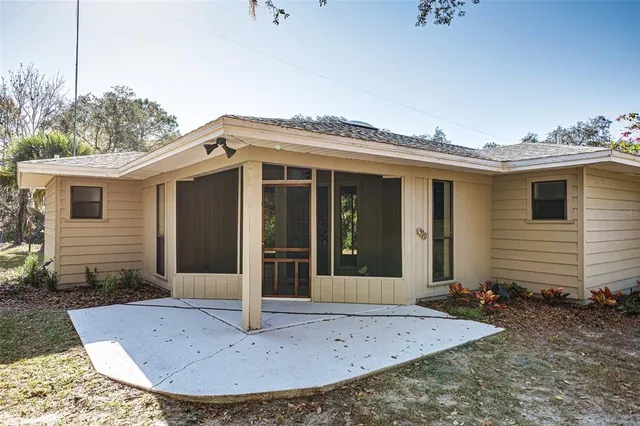 a view of a house with a small yard and potted plants