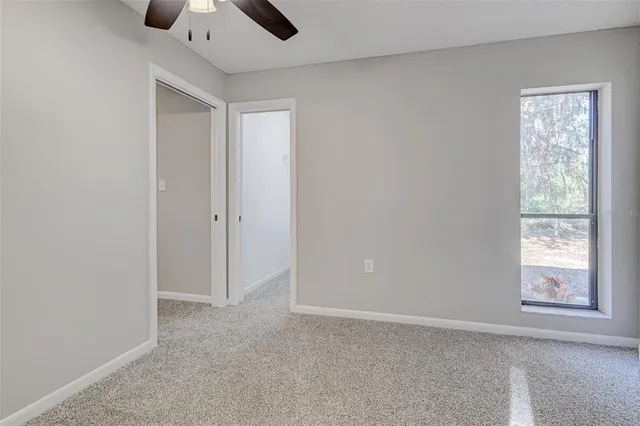 a view of a bedroom with furniture and window