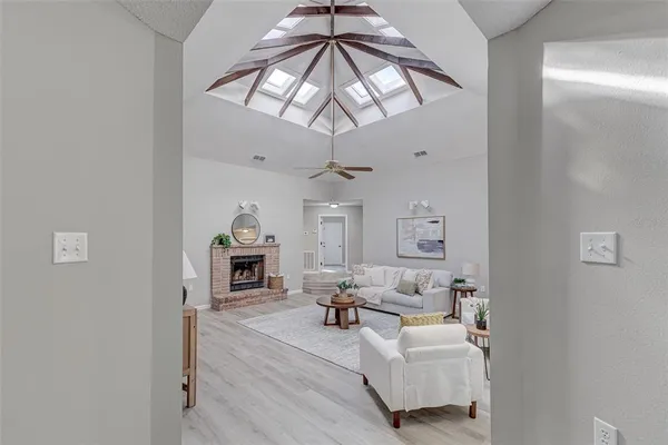 a living room with furniture a fireplace and a chandelier