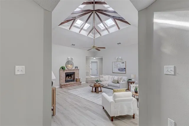 a living room with furniture a fireplace and a chandelier