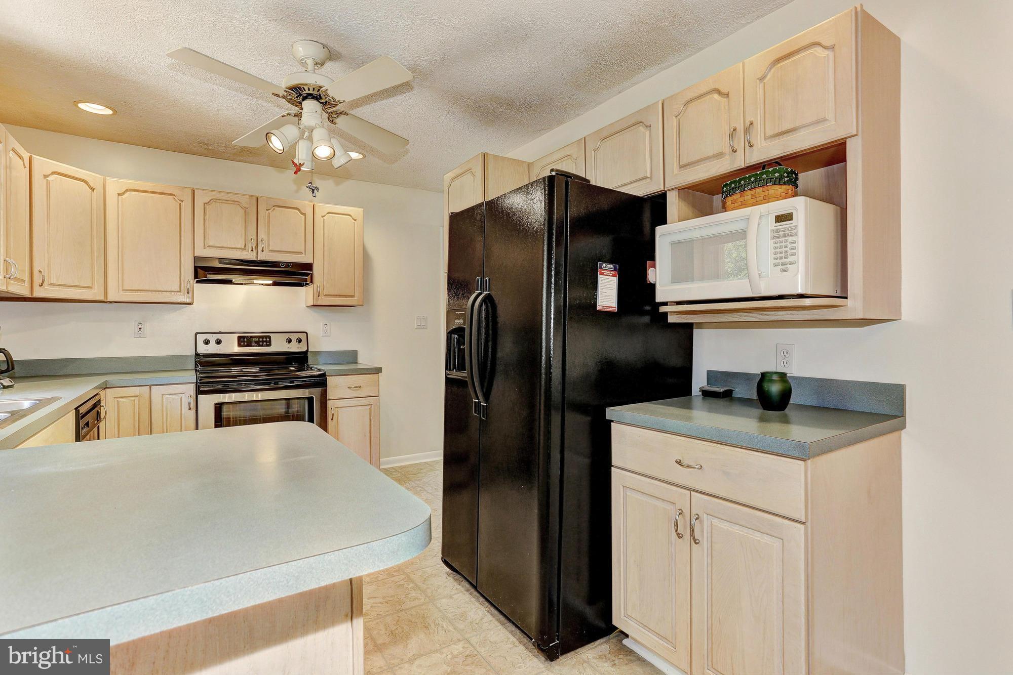 4149 Salem Bottom Road Westminster, MD 21157 - Photo 7 of 25 a kitchen with granite countertop a refrigerator a sink a stove and cabinets