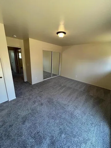 a view of a hallway and a room with a mirror