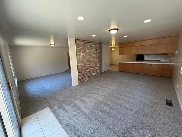 a kitchen with stainless steel appliances kitchen island granite countertop a refrigerator a stove top oven a sink and dishwasher