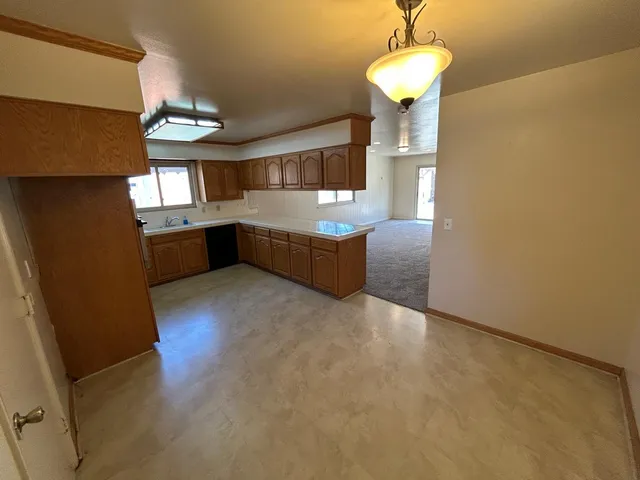 a large kitchen with stainless steel appliances granite countertop a refrigerator and a stove top oven