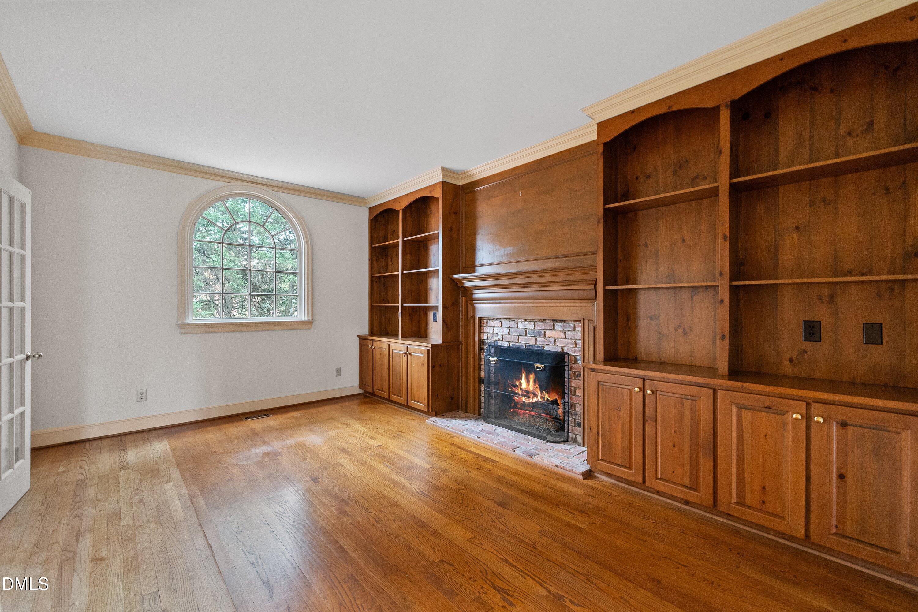 1708 Sawgrass Court Raleigh, NC 27615 - Photo 17 of 60 an empty room with wooden floor and fireplace