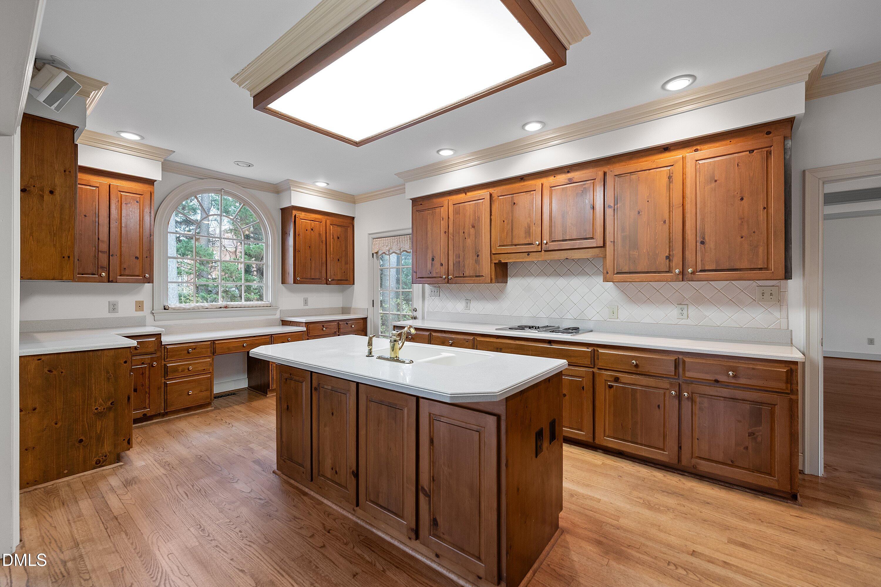 1708 Sawgrass Court Raleigh, NC 27615 - Photo 21 of 60 a kitchen with stainless steel appliances granite countertop wooden cabinets a sink dishwasher a stove and a refrigerator with wooden floor