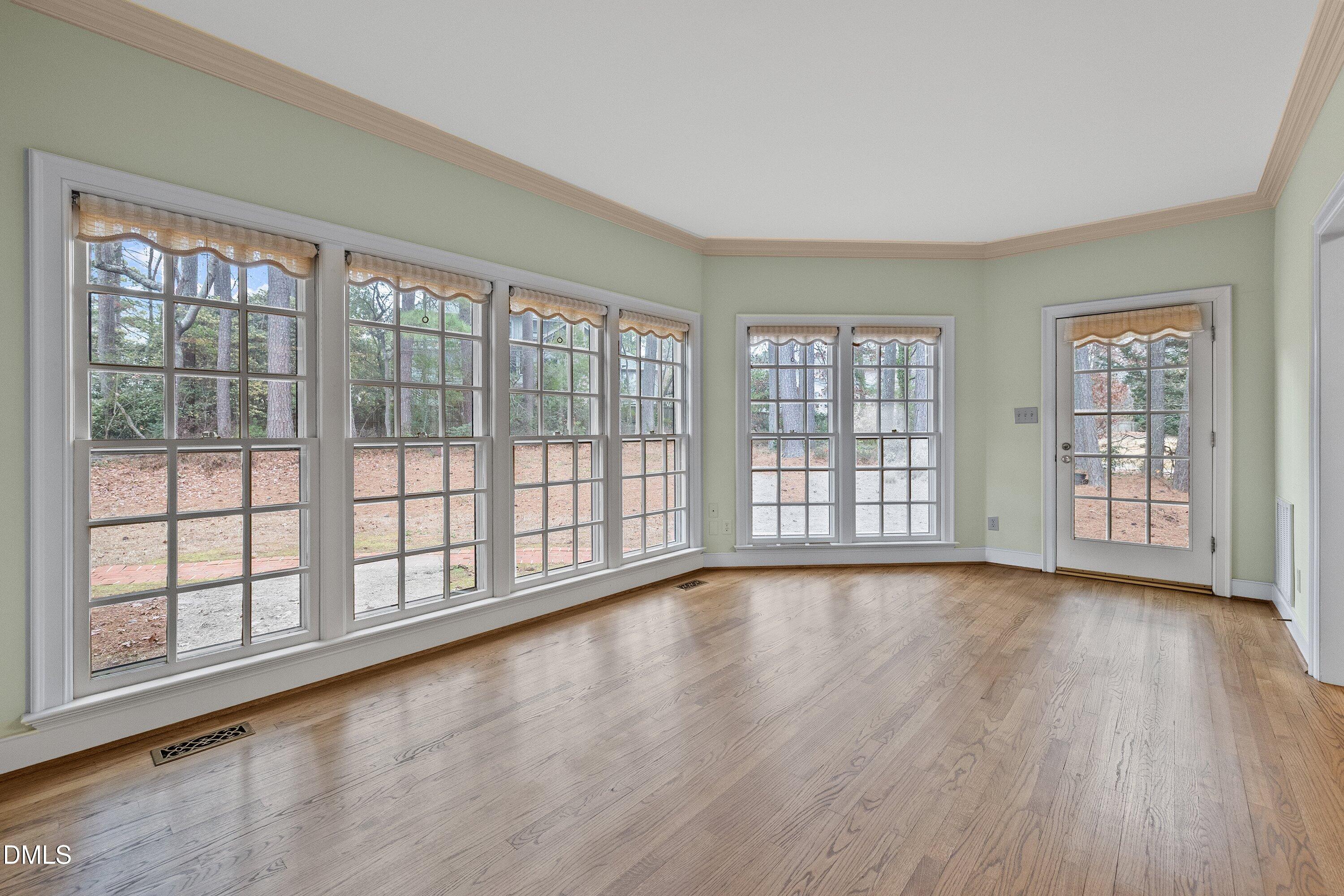 1708 Sawgrass Court Raleigh, NC 27615 - Photo 26 of 60 a view of an empty room with wooden floor and windows