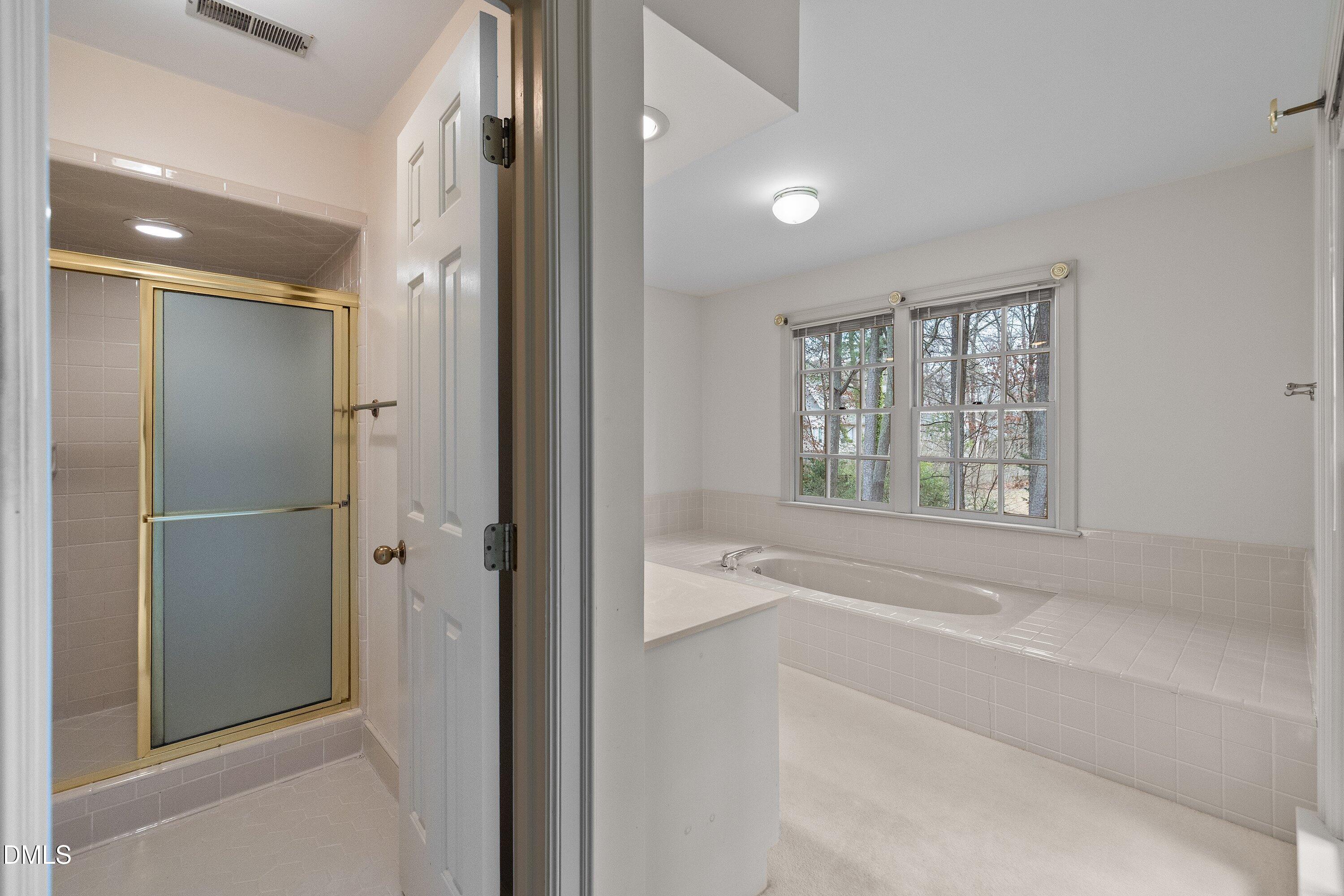 1708 Sawgrass Court Raleigh, NC 27615 - Photo 38 of 60 a bathroom with a bathtub and shower