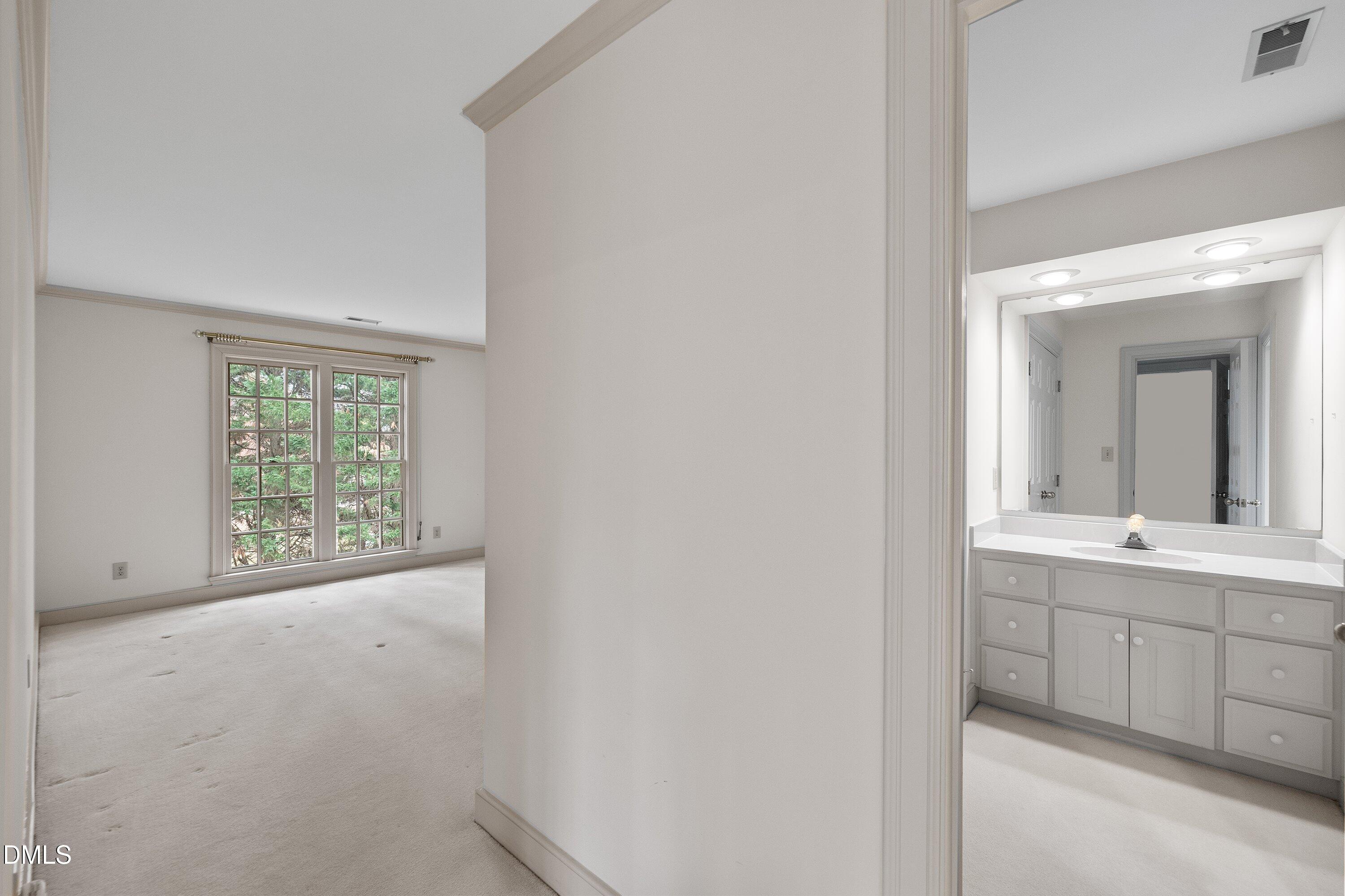1708 Sawgrass Court Raleigh, NC 27615 - Photo 43 of 60 a view of a room that has a sink and a large mirror next to a window