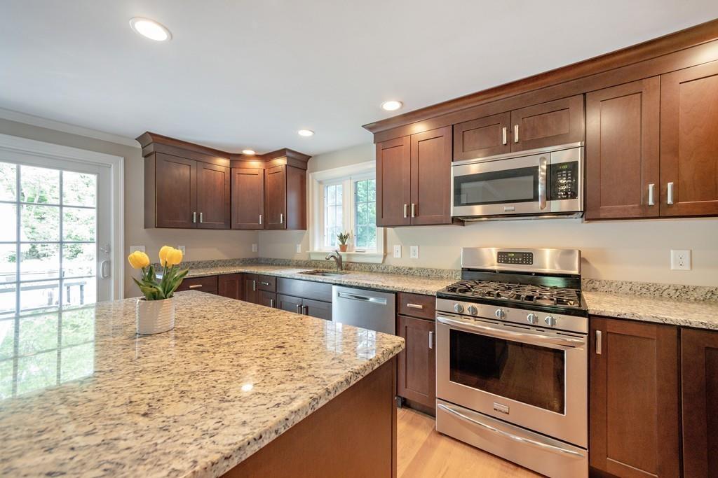 7 Peter Road North Reading, MA 01864 - Photo 12 of 32 a kitchen with stainless steel appliances granite countertop a stove microwave and sink