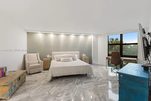 a spacious bedroom with a bed a couch and large window